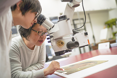 ◎ 香港康文署文物修復辦事處平面文物分組的負責人楊甦(右)與文物修復師郎翠妍在討論(一月十五日攝)。(新華社記者 呂小煒 攝)