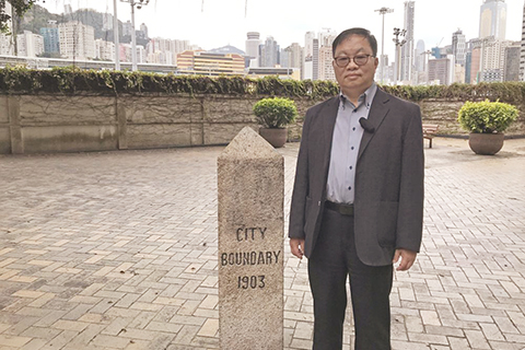 ◎ 地政總署測繪處總土地測量師余壽松,身旁為豎立在跑馬地黃泥湧道、有逾百年歷史的「維多利亞城」界石。(香港中通社圖片)