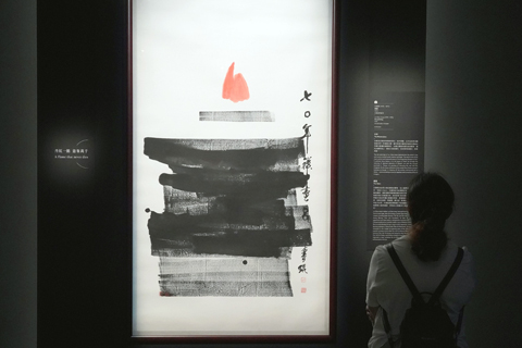 ◎ 觀眾欣賞香港著名水墨畫家呂壽琨的代表作《禪畫》。該作品是香港藝術館「鎮館之寶」之一。畫作將西方藝術的抽象元素結合中國水墨畫的虛實相生,以層次豐富的墨色表現蓮葉,襯托出躍然紙上、猶如火焰的蓮花,仿如頓悟的靈光,意象深邃。(中新社記者張煒 攝)