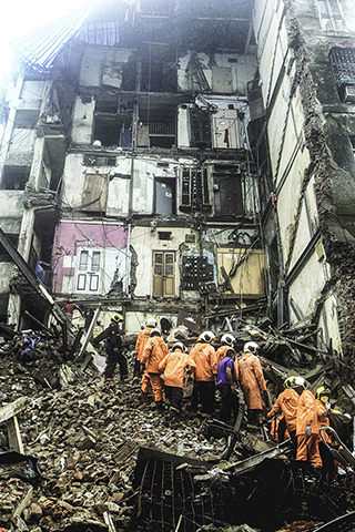 樓房倒塌 ◎ 七月十六日,救援人員在印度孟買的樓房倒塌現場工作。(新華社)
