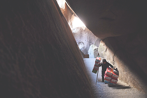 ◎ 十一月十三日,徐勝利挑著物資前往天池峰。(新華社記者劉軍喜攝)