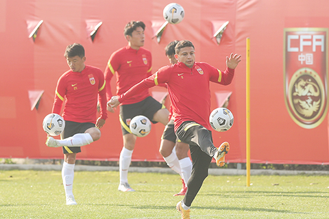 ◎ 三月二十二日,國足球員艾克森(前右)在訓練中。中國國家男子足球隊繼續在上海訓練,備戰男足世界杯預選賽四十強賽。(新華社 丁汀 攝)
