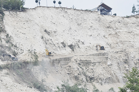 ◎ 九月六日,四川瀘定縣磨西鎮,兩台挖掘機正全力搶通海螺溝景區進出道路。(中新社記者張浪攝)