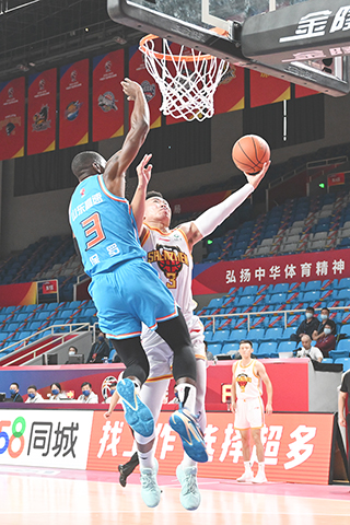 ◎ 十月十日,山東高速隊球員保羅(左)在比賽中防守深圳馬可波羅隊球員賀希寧。在浙江杭州進行CBA第一階段第一輪比賽中,深圳馬可波羅隊以一百零二比九十戰勝山東高速隊。(新華社記者 陳振海 攝)