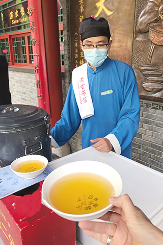 老舍茶館門口賣茶的男服務員。