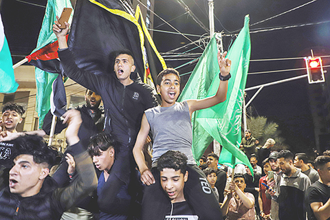 ◎ 五月十三日,巴勒斯坦人在加沙城街頭慶祝停火協議達成。 巴勒斯坦伊斯蘭聖戰組織(傑哈德)官員十三日晚說,傑哈德已同以色列達成停火協議。這名要求匿名的官員對新華社記者說,在埃及的斡旋下,傑哈德同以色列達成停火協議,協議於當地時間十三日廿二時(北京時間十四日三時)正式生效。(新華社發 里澤克.阿卜杜勒賈瓦德 攝)