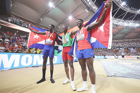◎ 來自非洲布基納法索的贊戈(中)昨晨以十七米六四奪得三級跳世界冠軍,亞軍季軍是古巴選手。(新華社發)