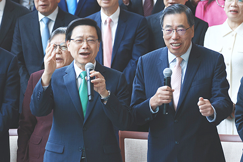 ◎ 十一月十七日,香港立法會議員在立法會綜合大樓宴會廳,與特區行政長官李家超、行政會議成員及政府高級官員進行午宴。圖為午宴前的合照環節,特區行政長官李家超(左)、立法會主席梁君彥(右)和立法會議員一起高呼區議會選舉口號,呼籲市民踴躍投票。(香港中通社記者 許其皓 攝)