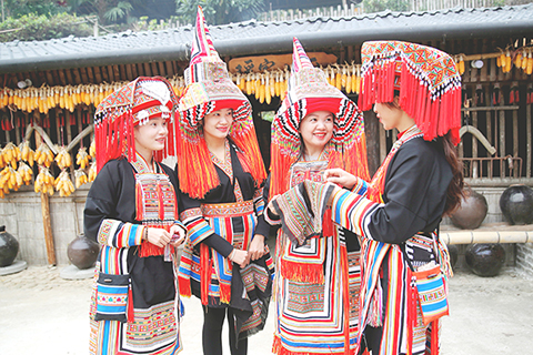 ◎ 二0二三年十一月十五日,李素芳(右二)與其他繡娘交流瑤繡技藝。(受訪者供圖)