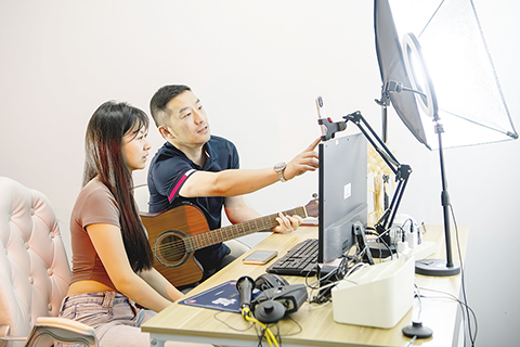 ◎ 集美大學畢業的台青李佳勛(左)在廈門「台青創客家」直播間裡學習電商直播帶貨(六月十四日攝)。