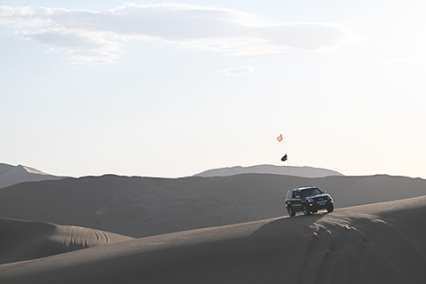 ◎ 一輛越野車在巴丹吉林沙漠中穿行(七月三十日攝)。(新華社記者貝赫 攝)