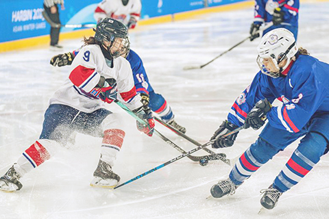 ◎ 二月八日,韓國隊球員朴宗伽(左)和中國台北隊球員林洋萁在比賽中拼搶。亞冬會女子冰球小組賽B組比賽中,中國台北隊二比三不敵韓國隊。(新華社記者 孫非 攝)