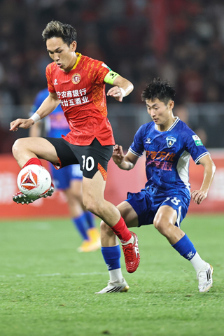 ◎ 六月二十八日,中國足球甲級聯賽第十四輪比賽中,遼寧鐵人農商銀行隊主場一比一戰平南京城市隊。圖為遼寧鐵人農商銀行隊球員邦本宜裕(左)在比賽中拼搶。(中新社記者于海洋 攝)