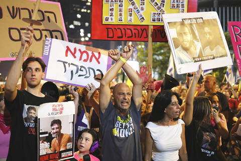 ◎ 八月九日,以色列民眾手持被扣押人員的海報在特拉維夫參加遊行集會。數以萬計以色列民眾當日晚在位於特拉維夫的以國防軍總部前舉行大規模遊行集會,抗議以軍接管加沙地帶北部加沙城計劃,要求迅速結束在加沙地帶的戰爭。一個代表大多數被扣押人員家屬的團體當晚發表聲明說,超過十萬人參加了遊行集會。(新華社發 賈馬爾·阿瓦德 攝)