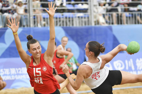 ◎ 八月十一日,德國隊球員德拉克斯勒(左)在比賽中防守丹麥隊球員約恩森。成都世運會沙灘手球女子半決賽中,德國隊戰勝丹麥隊,晉級決賽。(新華社記者 張博文攝