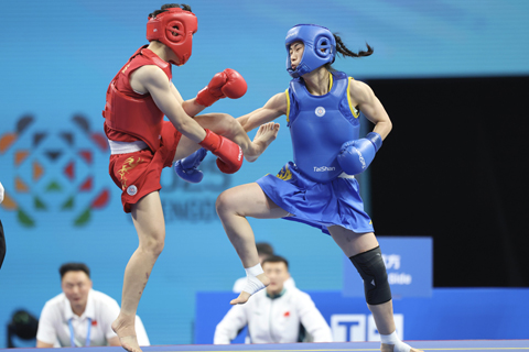 ◎ 八月十二日晚,成都世運會武術散打女子六十公斤級決賽中,中國選手李志勤以二比0勝越南選手阮氏秋水奪得冠軍。圖為李志勤(藍方)在比賽中。(中新社記者 張浪 攝)