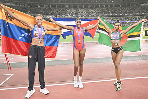 ◎ 九月十八日,冠軍古巴選手靴南迪斯(中)、亞軍多米尼克選手特亞.拉豐(右)和季軍委內瑞拉選手羅哈斯在決賽後合影。世界田徑錦標賽女子三級跳遠決賽在日本東京舉行。(新華社記者 宋彥樺 攝)