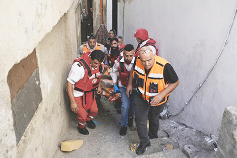 ◎ 巴勒斯坦紅新月會醫護人員抬著馬吉德.達烏德的屍體,據巴勒斯坦衛生部稱,達烏德於十月十九日在約旦河西岸艾因難民營的以色列軍事行動中喪生。(美聯社圖片/Majdi Mohammed)
