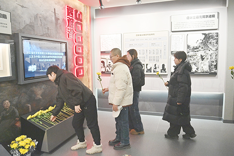 ◎ 十二月十二日,吉林長春,觀眾在參觀「鐵證如山——日本侵華罪行檔案展」時,向死難同胞敬獻鮮花。(中新社記者張瑤 攝)