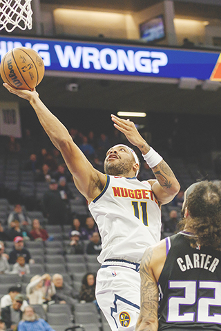 ◎ 丹佛金塊後衛布魯斯.布朗(11)在十二月十一日於加州沙加緬度舉行的NBA常規賽下半場,壓過沙加緬度帝王隊後衛德文.卡特(22),上籃。是役,金塊以一百三十比一百零五大勝帝王。(美聯社/Randall Benton)