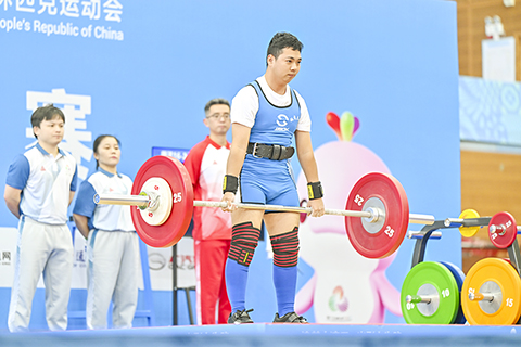 ◎ 十二月十二日,在廣東中山進行的全國第十二屆殘疾人運動會暨第九屆特殊奧林匹克運動會特奧舉重比賽進入決賽日,十六支代表隊的運動員在賽場上展開角逐,向獎牌發起衝擊。圖為廣東隊何壅健收穫男子-十六至二十一歲組六十公斤級深蹲、臥推、提鈴冠軍。(中新社記者 陳驥旻 攝)