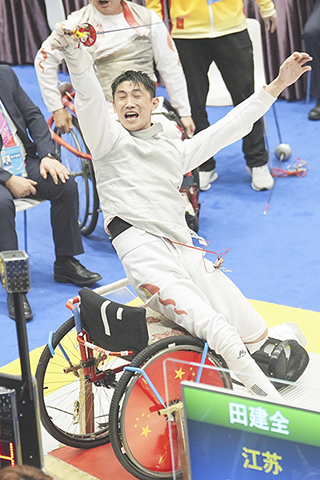 ◎ 十二月十二日,江蘇隊選手田建全在半決賽中慶祝獲勝。最終,江蘇隊四十五比四十四戰勝上海隊,晉級決賽。當日,全國第十二屆殘疾人運動會暨第九屆特殊奧林匹克運動會輪椅擊劍項目男子花劍團體比賽在香港舉行。(新華社記者 侯俊 攝)