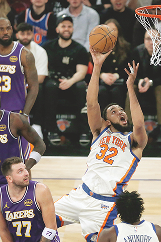 ◎ 二月一日,紐約,NBA常規賽的上半場,紐約人隊中鋒卡爾-安東尼-唐斯(32)在洛杉磯湖人隊前鋒勒勢占士、中鋒德安德魯-艾頓(5)與後衛盧卡-當錫(77)面前投籃。是役,紐約人以一百一十二比一百捍衛主場。(美聯社/約翰·曼森)