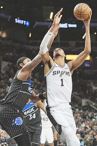 ◎ 二月一日,聖安東尼奧馬刺隊前鋒維克多·溫班亞馬(1)在NBA常規賽的下半場,越過奧蘭多魔術隊前鋒保羅·班切羅(左)投籃 。是役,馬刺以一百一十二比一百零三主場驅趕魔術。(美聯社/埃里克·蓋伊)