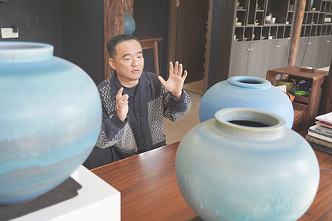 ◎ 二0二六年春節,成都彭州海窩子古鎮,蔡兆慶與他的「湔江藍」系列作品。(中新社記者 呂楊 攝)