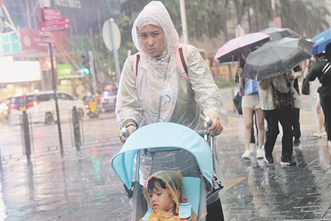 ◎ 六月十六日,市民遊客在雨中出行。香港天文台表示,香港受活躍西南季候風及低壓槽影響,間中有驟雨和狂風雷暴,部份地區雨勢較大,提醒市民留意天氣變化。(香港中通社記者 鄧梓傑 攝)