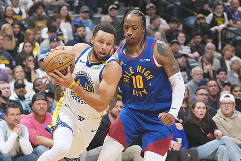 ◎ NBA昨早勇士客勝金塊二十分。圖為居里進攻,主隊迪羅辛難防,金塊一一四比一三四敗陣。(美聯社)